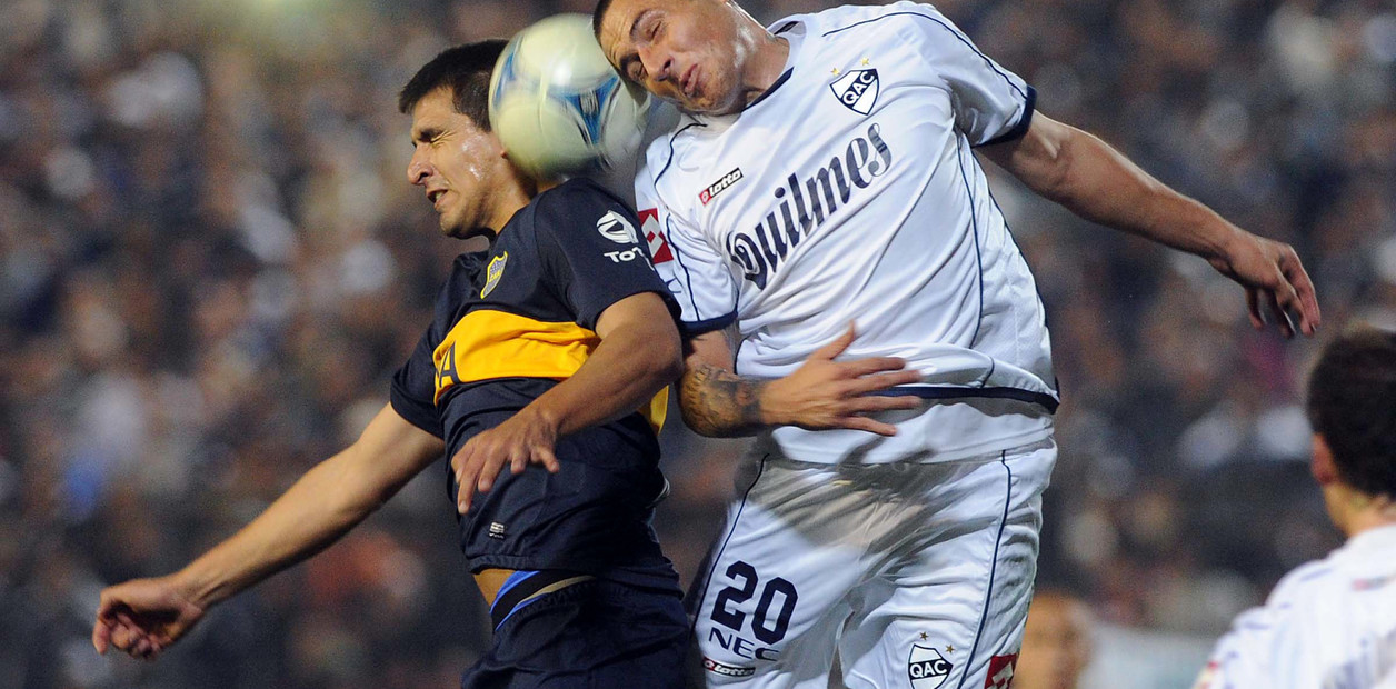 Olivera y Viatri disputan la pelota en Quilmes–Boca